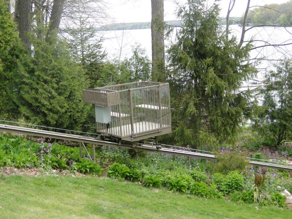 Hillside tram installation running down a wooded slope to a dock